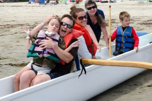 family in kayak at day on the beach