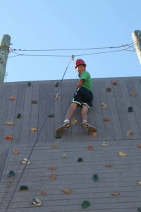 Kid reaching the top of a rock climbing wall