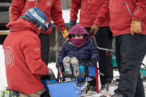 young person on sledding on an adaptive sport sled